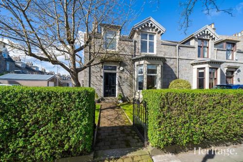 a large house with bushes in front of it at Fountainhall Luxury Townhouse, Aberdeen City Centre in Aberdeen