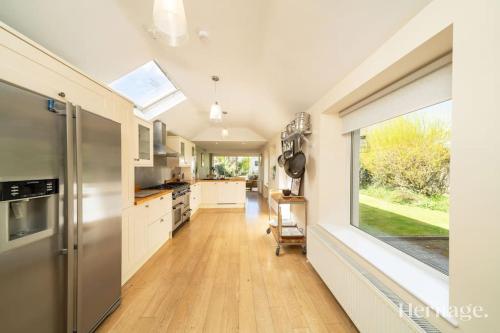 a kitchen with white cabinets and a large window at Fountainhall Luxury Townhouse, Aberdeen City Centre in Aberdeen