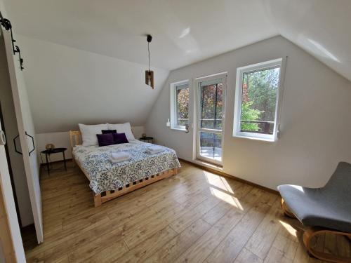 a bedroom with a bed and two windows at Całkiem Klawa Enklawa in Brzozie