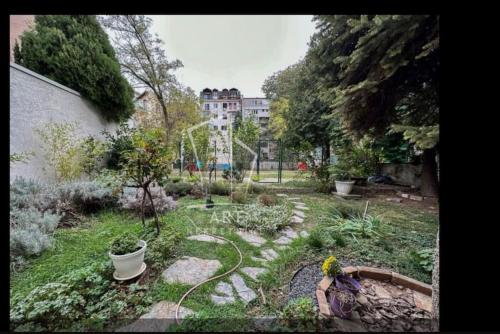 un jardín con una manguera en un patio con un edificio en Cozy apartment in Vračar +garden, en Belgrado