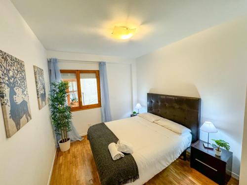 um quarto com uma cama grande e uma janela em Laurel del Pilar ComoTuCasa em Zaragoza