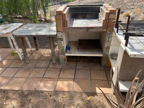an outdoor kitchen with two tables and an oven at Chayofa Blue in Chayofa
