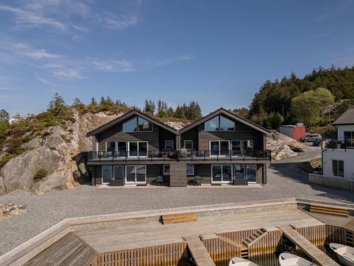 Eksklusiv Rorbu - Havblikk 2 - Båtutleie في Bekkjarvik: منزل على قمة جبل مع ممر