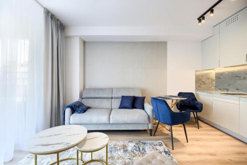 a living room with a couch and a table and chairs at AboutArtApartments - Otyńska 4 in Wrocław