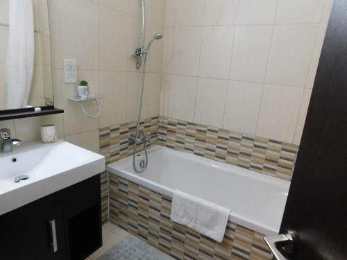 uma casa de banho com uma banheira e um lavatório em Paramount Gardens Resorts C201 em Lárnaca