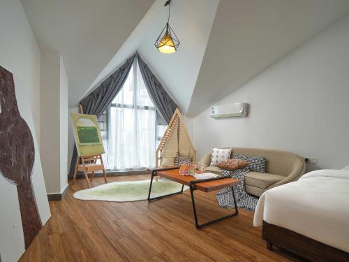 a room with a bed and a couch and a table at Zhangjiajie Yeah Hostel in Zhangjiajie
