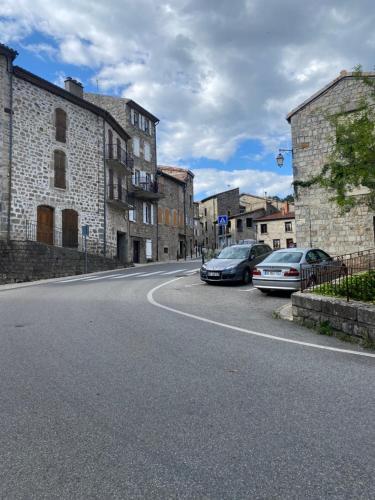une rue avec des voitures garées sur le bord de la route dans l'établissement Appartement atypique, à Largentière