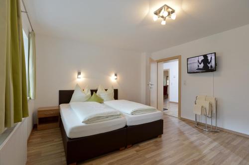 a bedroom with a bed with white sheets at Ferienwohnungen Tiroler Haus in Mayrhofen