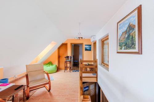 sala de estar con escalera, mesa y sillas en Apartment & Rooms Bruna Vučič, en Bovec