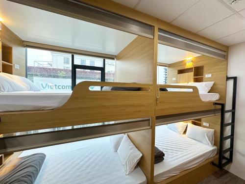 a room with three bunk beds in it at Hanoi Capsule Station Hostel in Hanoi