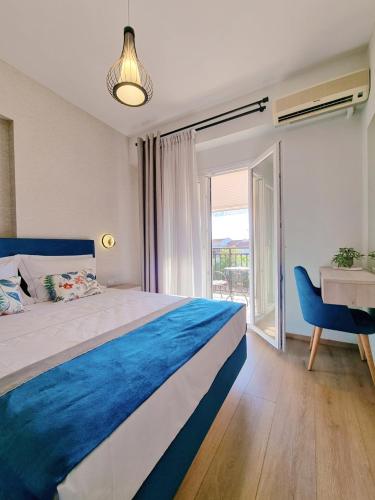 a bedroom with a blue and white bed and a desk at Studios Despina in Limenaria