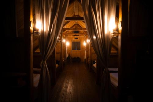 um quarto escuro com um corredor com camas e luzes em Wilderness Center / Óbyggðasetur Íslands em Óbyggðasetur