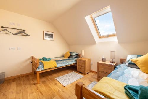 a attic bedroom with two twin beds and a window at Spacious 6 bedroom property on a working fruit farm in Tore