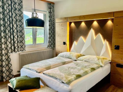- une chambre avec un grand lit et une fenêtre dans l'établissement Kornbranntgut Hieflau, à Hieflau
