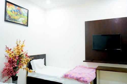 a hotel room with a bed and a flat screen tv at Hotel In Jangpura Bhogal in New Delhi