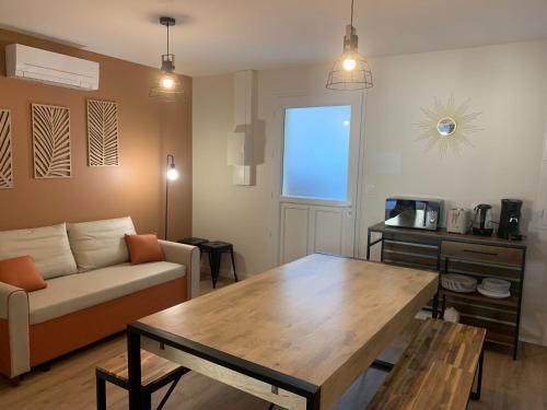 a living room with a couch and a wooden table at Hôtel Des Docks in Digoin