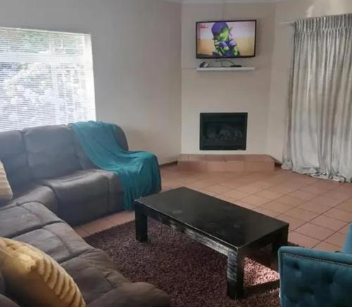 a living room with a couch and a coffee table at Lovely Holiday in Kempton Park