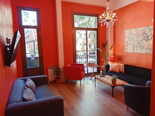 salon z czerwonymi ścianami i niebieską kanapą w obiekcie Paraiso Hostel w Barcelonie