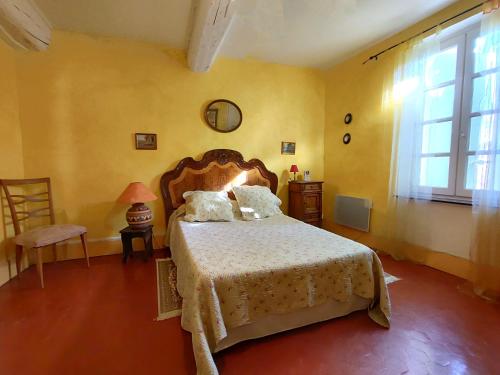 - une chambre avec un lit dans une pièce jaune dans l'établissement La Comtadine d'Oc, à Argeliers