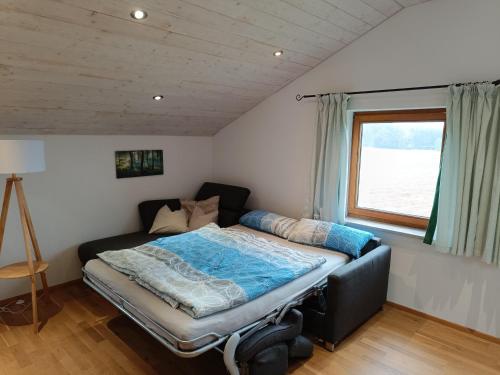 Bett in einem Zimmer mit Fenster in der Unterkunft Ferienwohnung auf dem Land in Tuntenhausen