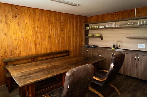 una sala da pranzo con tavolo e sedie in legno di Chatka na hřišti TJ Sokol a Ostravice