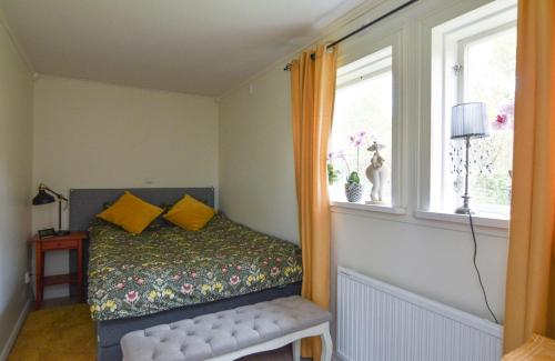 um quarto com uma cama com almofadas amarelas e uma janela em Mysigt HÄRBRE STUGA med utsikt över Siljan em Rättvik