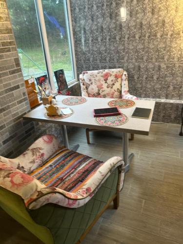 a table and chairs in a room with a window at Уютный номер с видом на горы in Makhinjauri