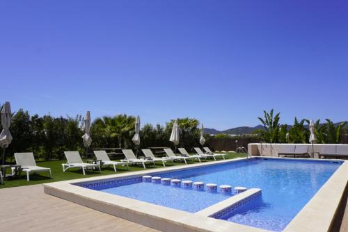 una piscina con tumbonas y una piscina en Los Escondidos Ibiza en Playa d'en Bossa