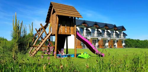 una estructura de madera frente a un edificio en Bieszczadzkie Siedlisko en Polańczyk