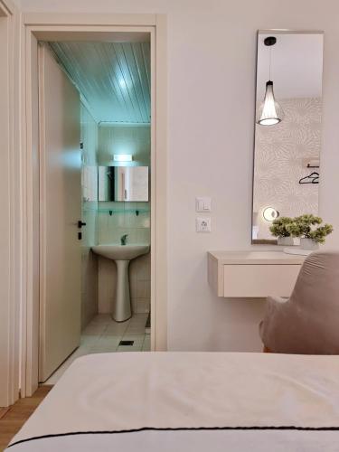 a bathroom with a sink and a mirror at Studios Despina in Limenaria