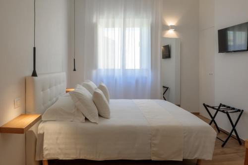 a bedroom with a white bed with a window at Blanco B&B - Group Puglia in Trani