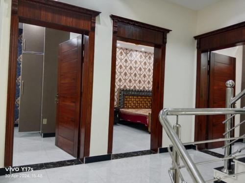 Pokój z 2 drewnianymi drzwiami i łóżkiem w obiekcie Shah jee guest house w mieście Jhelum