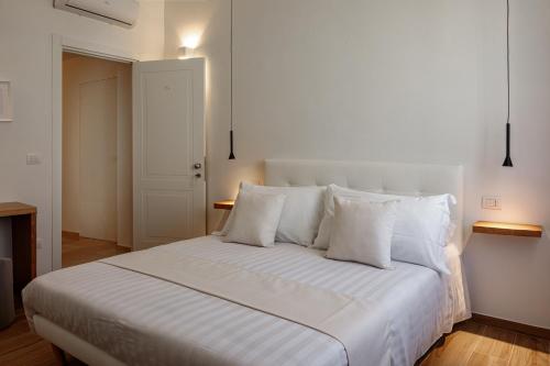 a white bed with white pillows in a bedroom at Blanco B&B - Group Puglia in Trani