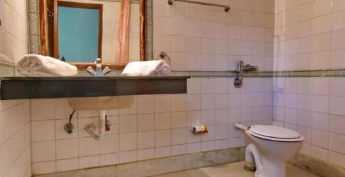 een badkamer met een toilet en een wastafel bij Goroomgo Hotel Casa Di William Khajuraho in Khajurāho