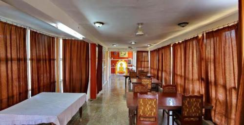 卡修拉荷的住宿－Goroomgo Hotel Casa Di William Khajuraho，配有窗帘、床和桌子的房间
