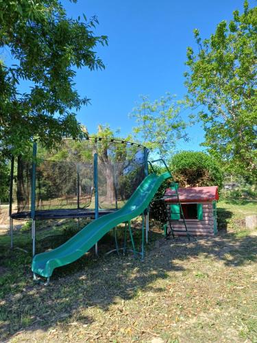um parque infantil com um escorrega e uma estrutura de jogos em La ferme d'Andréa au milieu des vignes à 3min à pied du centre piscine chauffée climatisation em Lourmarin