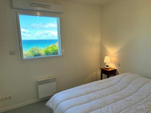 une chambre avec une fenêtre avec vue sur l'océan dans l'établissement 489 - Appart T2 surplombant la plage de Caroual., à Erquy