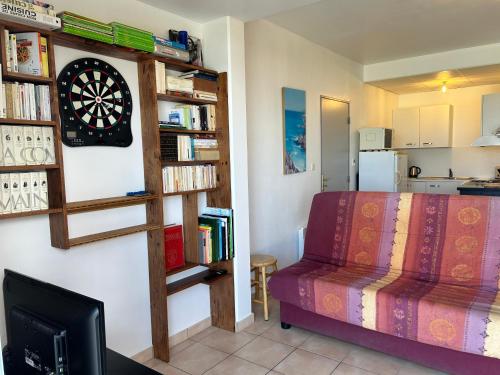 - un salon avec un jeu de fléchettes sur un mur dans l'établissement 489 - Appart T2 surplombant la plage de Caroual., à Erquy