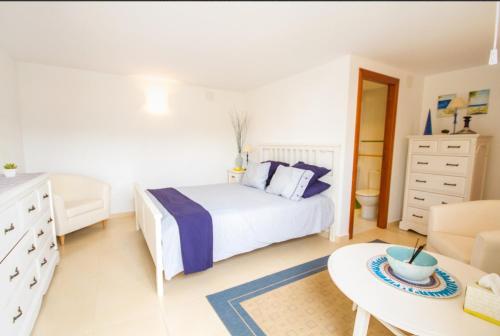 een witte slaapkamer met een bed en een tafel bij Villa El Huerto in Orba