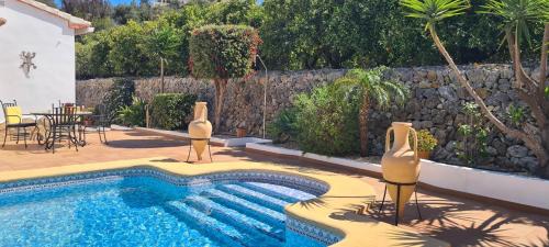 a swimming pool in a backyard with a table and chairs at Villa El Huerto in Orba