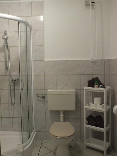 uma casa de banho com um WC e um chuveiro em Zimmer im Ferienpark Buntspecht em Pruchten