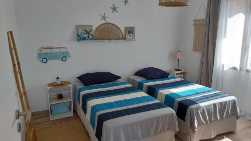 une chambre avec deux lits et une table avec une lampe dans l'établissement Maison proche de la mer, à Pianottoli-Caldarello