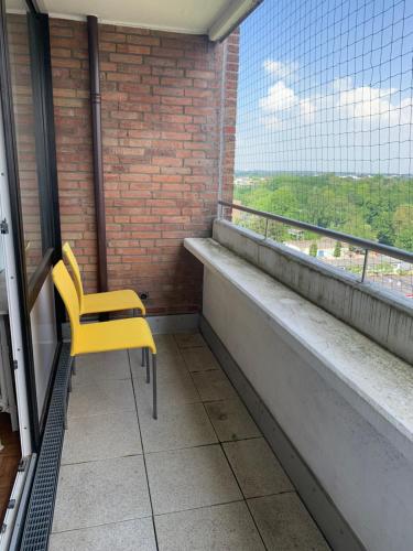 einem gelben Stuhl vor einem Fenster in der Unterkunft Business Apartment SPA walk to Fair & Rhine River in Düsseldorf