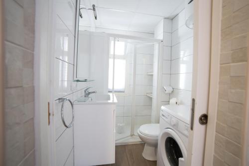 uma casa de banho branca com um WC e um lavatório em Los Barqueros 34 by Best Holidays Fuerteventura em Corralejo
