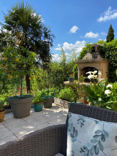 un jardin avec des pots de plantes et un four en pierre dans l'établissement Le Relais des Malettes Chambres d'hôtes B&B, à Francheville