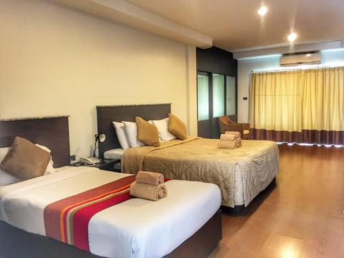 a hotel room with two beds in a room at Diamond Park Inn Chiangrai & Resort in Chiang Rai