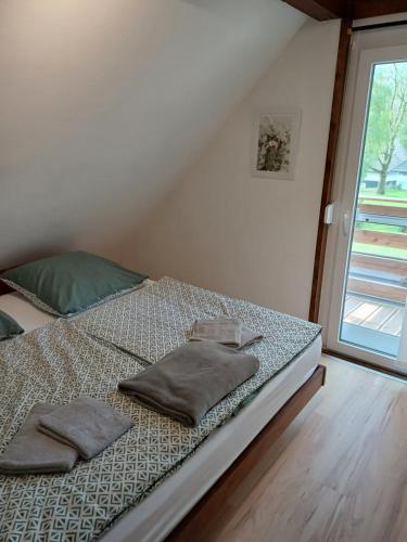 a bedroom with a bed with two pillows and a window at Ferienhaus 30 am Silbersee mit Badezuber in Frielendorf