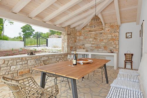 a patio with a wooden table and chairs at Casa Mirna for 7 people near Pula with sea view & only 2 km from the sea in Peruški