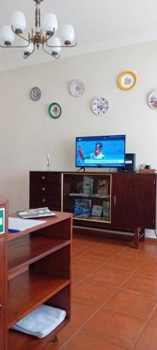 a living room with a flat screen tv on the wall at Caminho da Vila moradia. in Escalos de Cima
