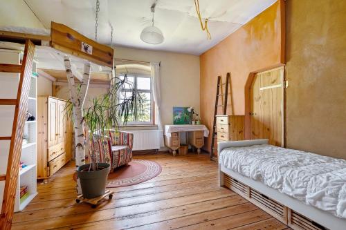 una camera con un letto e un albero di Ferienwohnung Ludwigslust Havelland a Rathenow